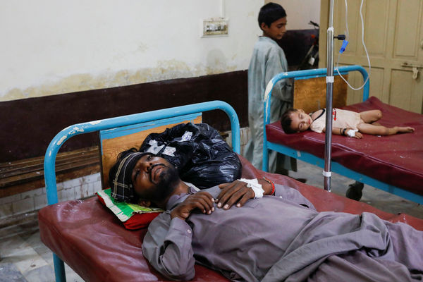 A patient rests after receiving medical assistance, following rains and floods during the monsoon season, in Jacobabad